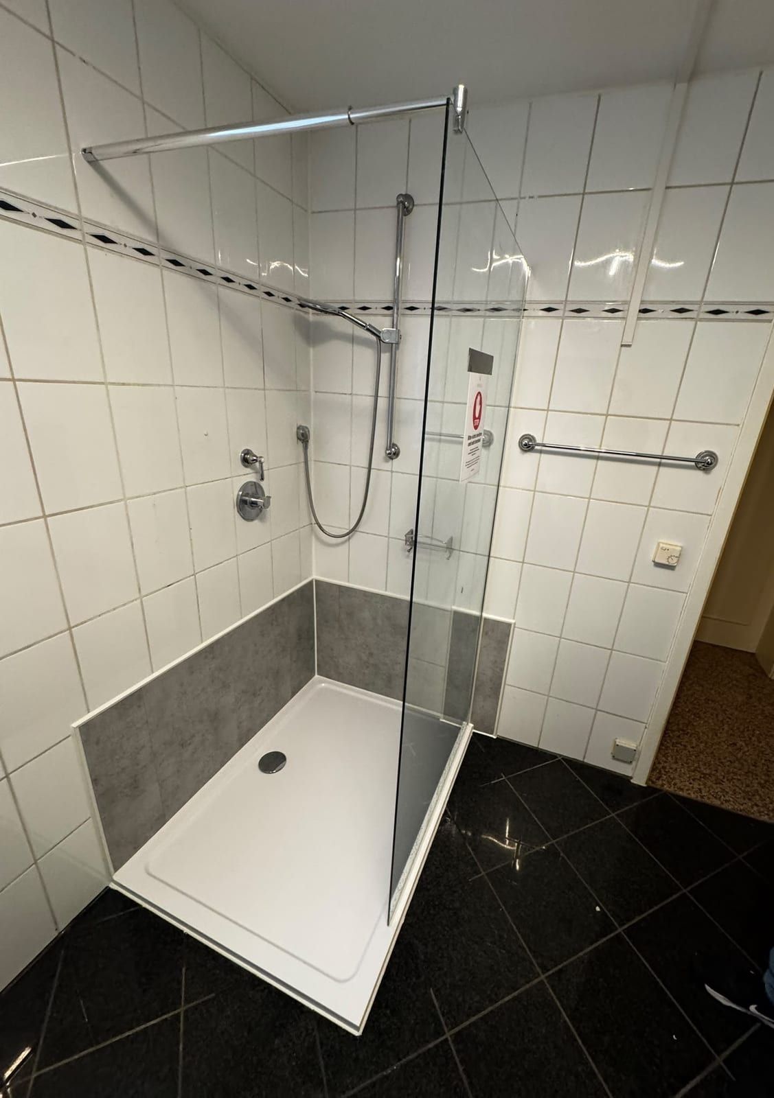 Nachher: flache, große Duschwanne mit Glaswand und Haltegriff