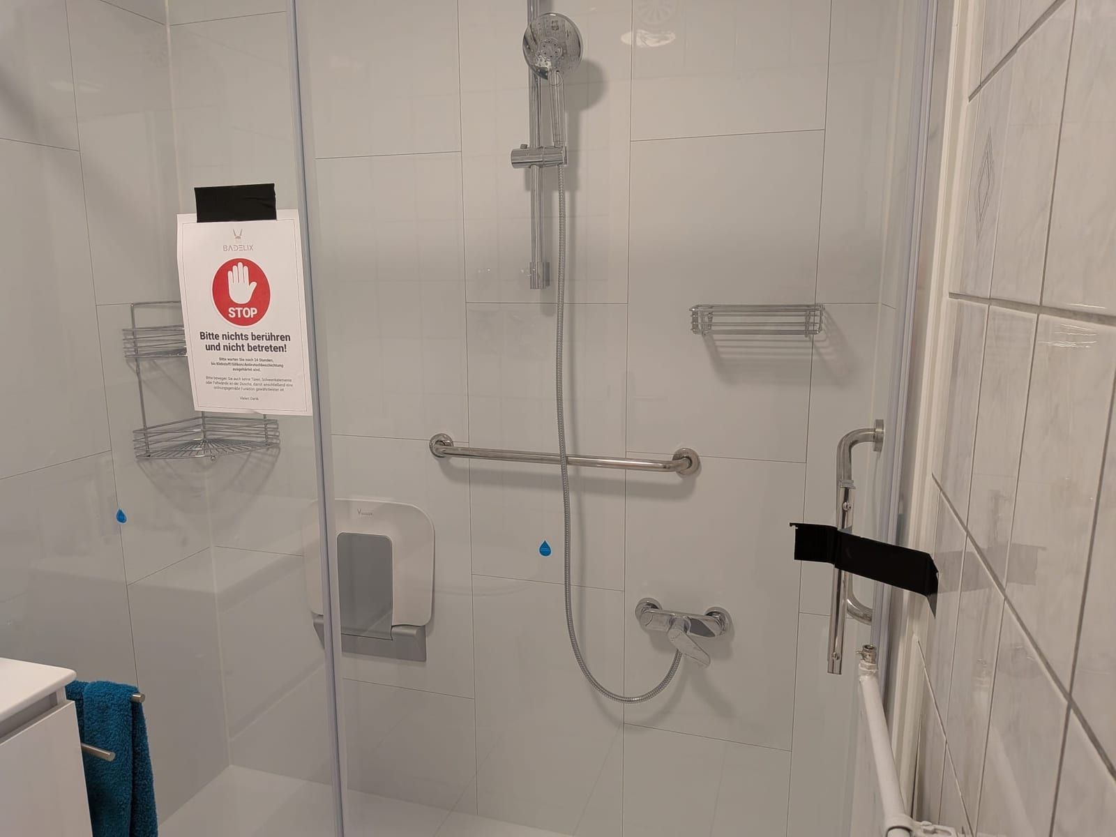 Nachher: Dusche mit Glaswand, Haltegriff und Klappsitz