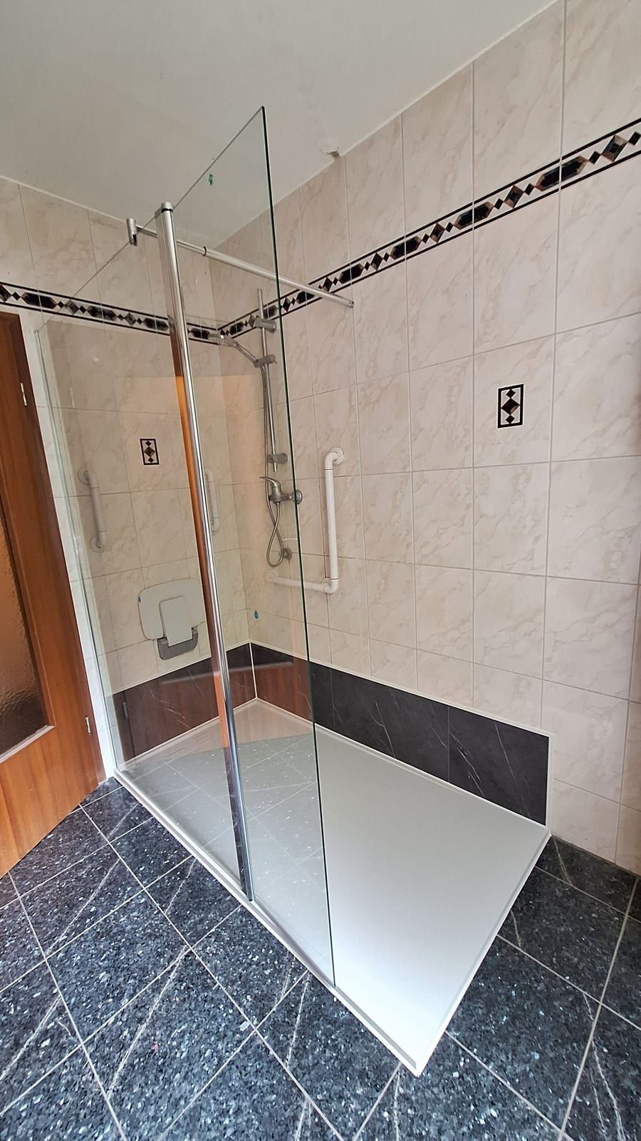 Nachher: bodennahe Dusche mit Glaswand, Haltegriff und Klappsitz