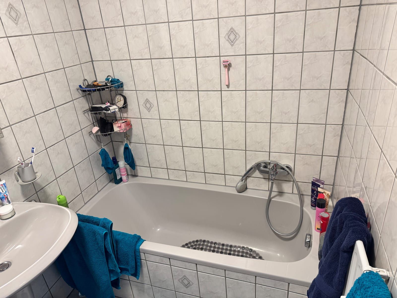 Vorher: Badewanne unter weißen Fliesen, daneben das Waschbecken
