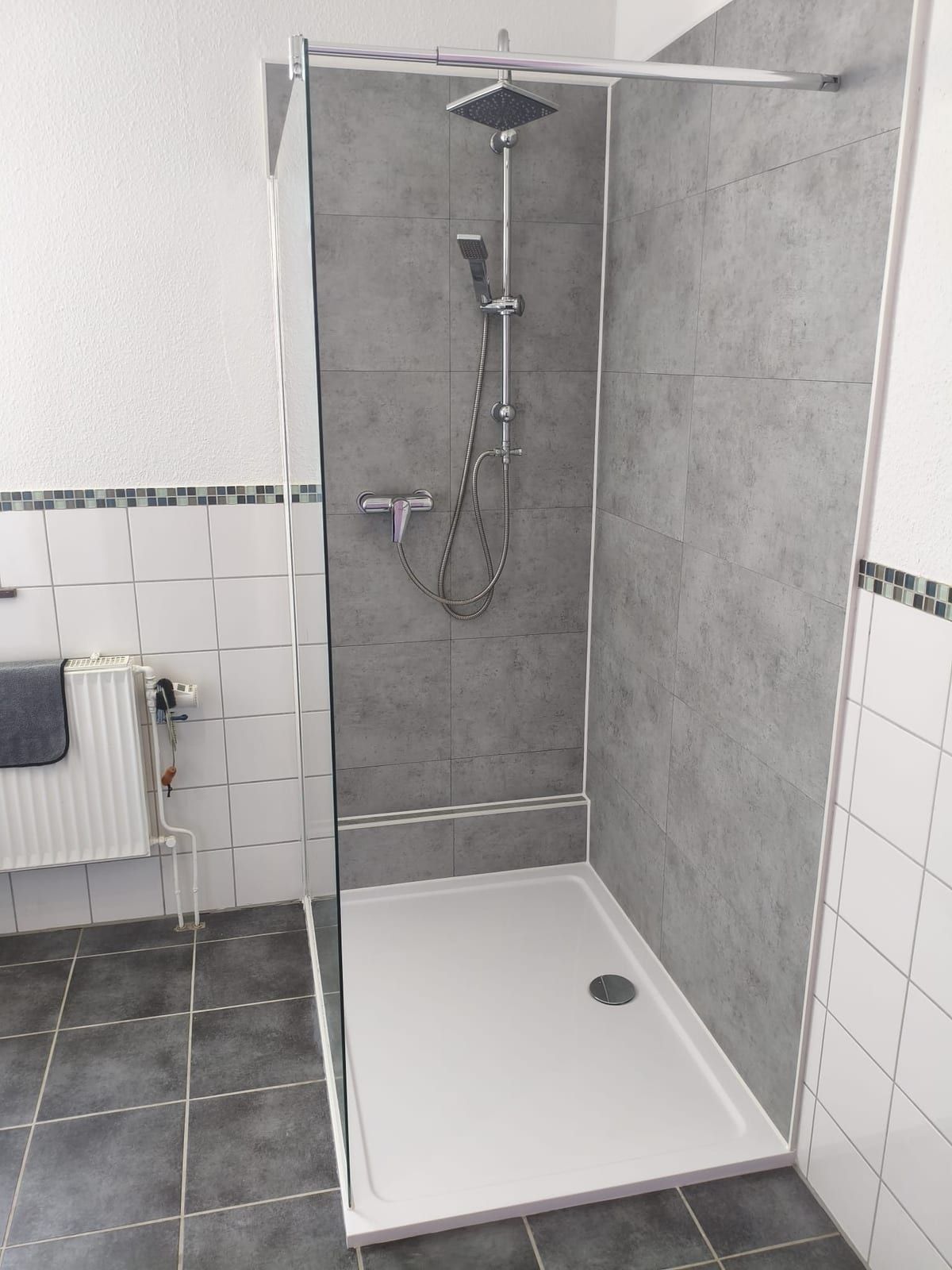 Nachher: flache Dusche mit grauen Wandpaneelen und Glastür