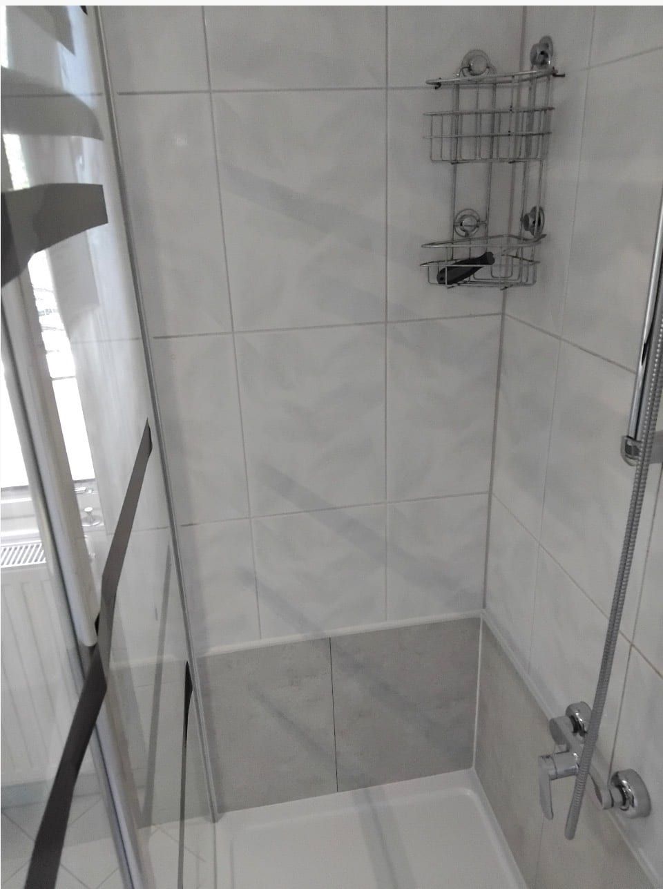 Nachher: Dusche mit Glaswand, Ablagen und hellen Wandpaneelen