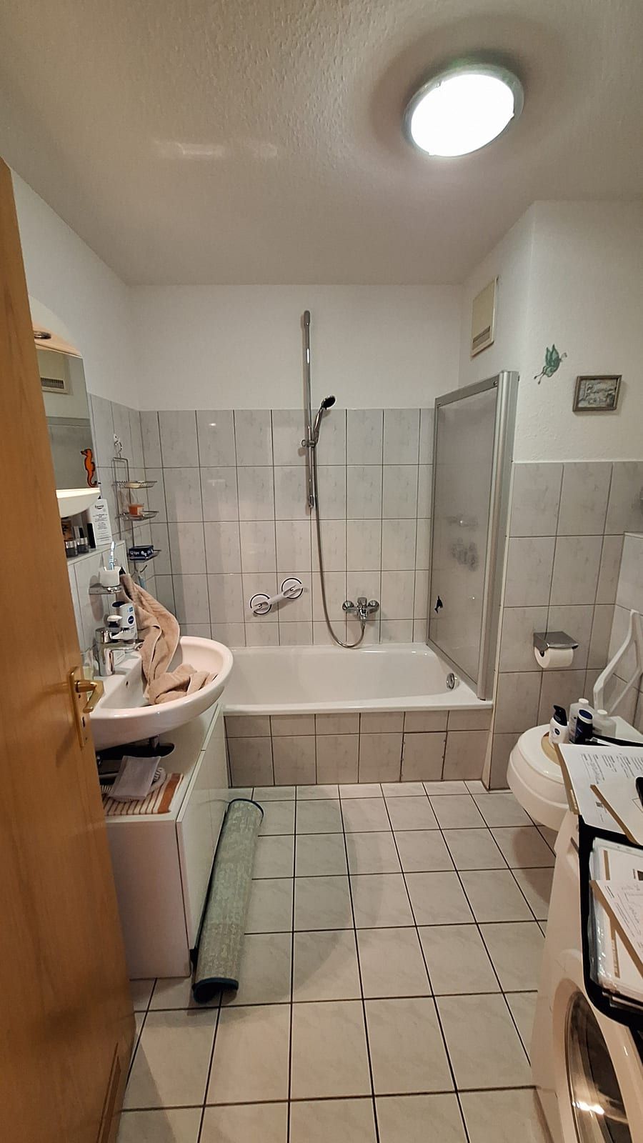 Vorher: Badewanne mit Glasaufsatz, daneben Waschbecken und WC