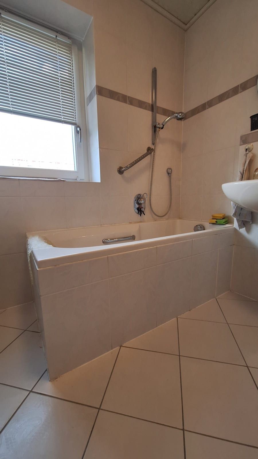 Vorher: Badewanne unter dem Fenster, Brausestange an der Wand