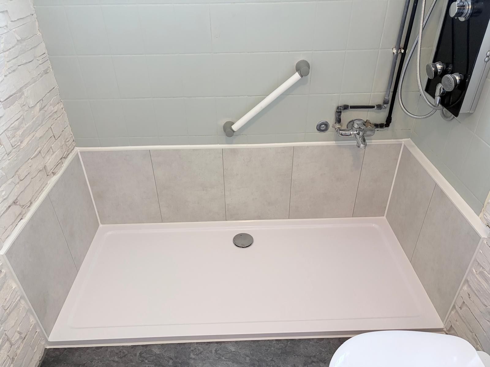 Nachher: flache Duschwanne an derselben Stelle, Haltegriff an der Wand